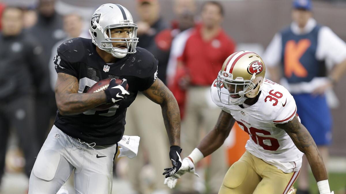 Oakland Raiders tight end Mychal Rivera, left, runs against San Francisco 49ers defensive back Dontae Johnson during the second half of the Raiders' 24-13 win Sunday.