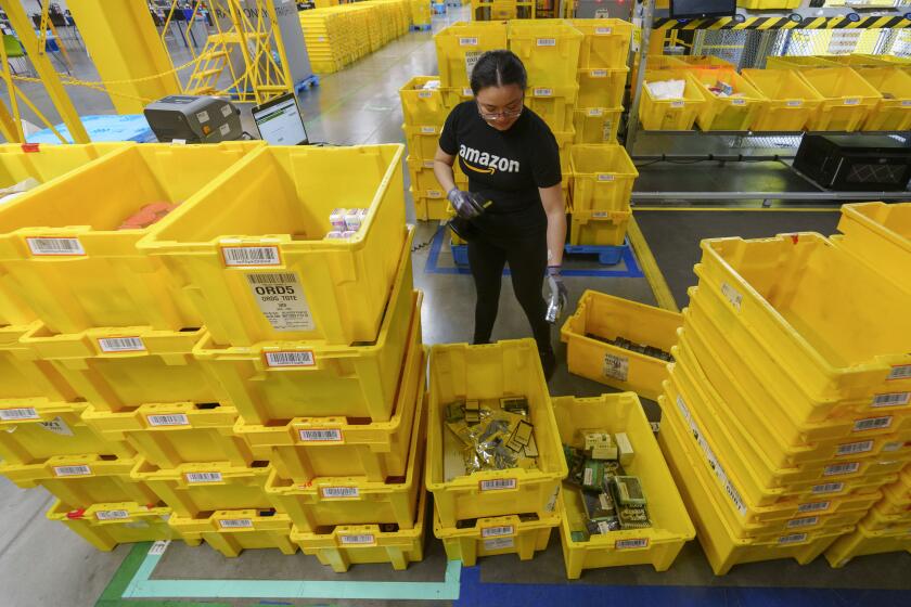 ARCHIVO – Una empleada escanea mercancías entrantes en una estación de recepción del centro de envío de pedidos OXR1 de Amazon en Oxnard, California, el 21 de agosto de 2024. (AP Foto/Damian Dovarganes, Archivo)