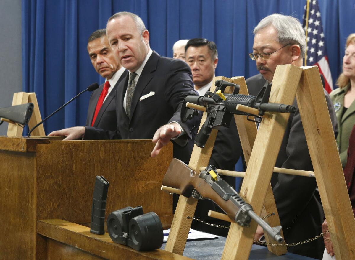 Senate President Pro Tem Darrell Steinberg, second from left, gestures to a pair of semi-automatic rifles as he discusses a package of proposed gun control legislation at a Capitol news conference in February. Eleven bills were signed into law.
