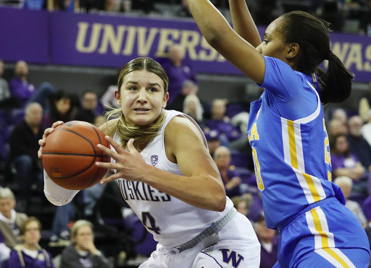 Washington guard Amber Melgoza, left, tries to move around UCLA guard Charisma Osborne during the first half of the Bruins' loss Sunday.