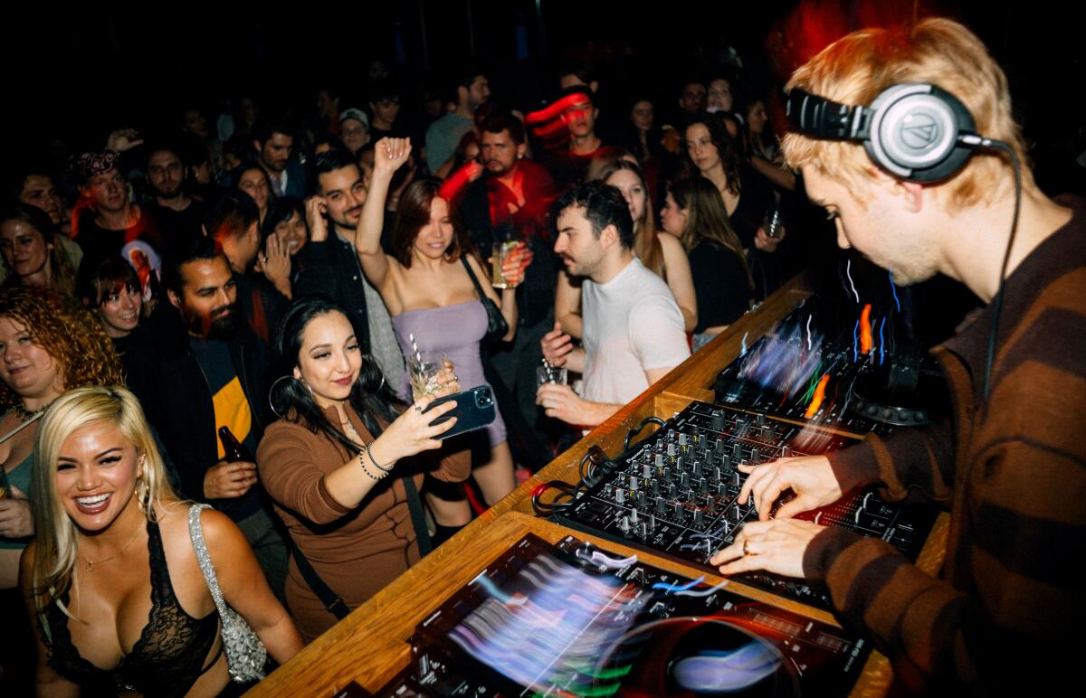 A DJ presiding over a packed dancefloor