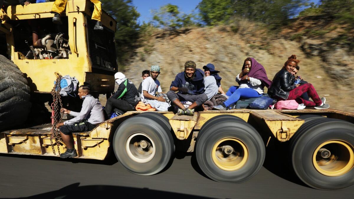Migrants traveling with a caravan hoping to reach the U.S. border hitch a ride on a truck on the highway between Mazatlan and Culiacan in Mexico on Nov. 14, 2018.