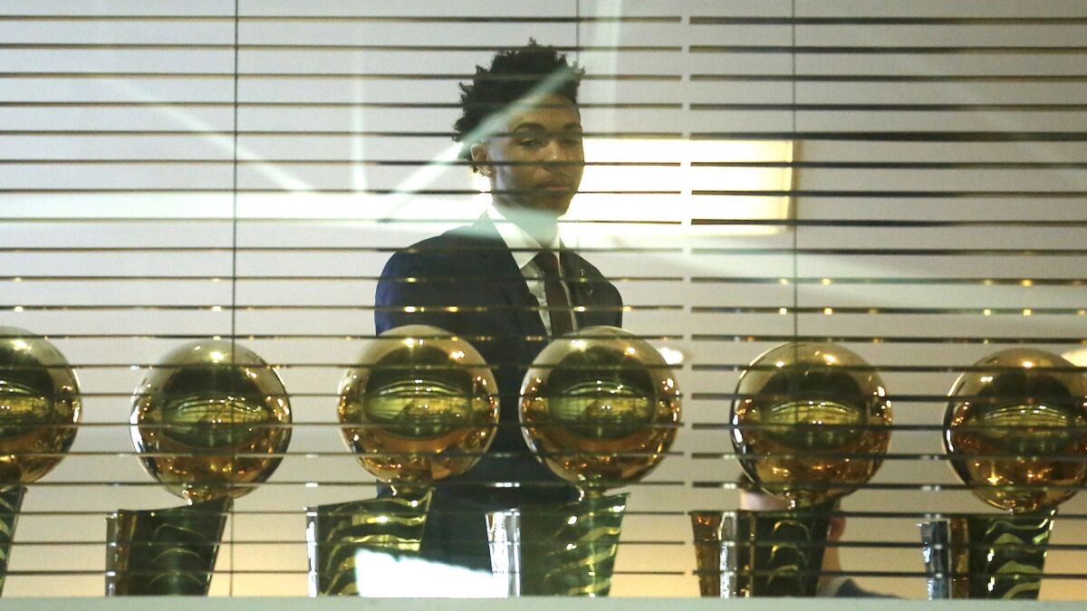 Lakers top draft pick Brandon Ingram looks over the Lakers' championship trophies prior to a news conference on Tuesday.