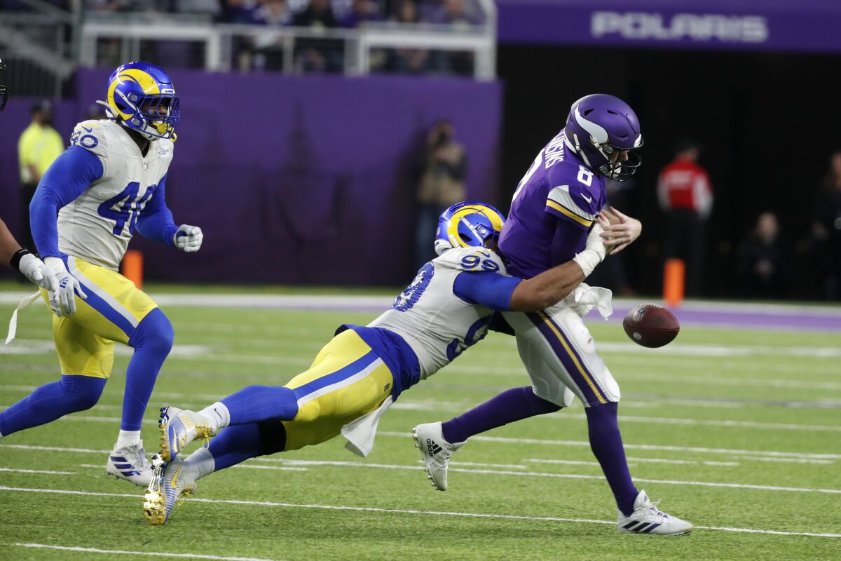 Minnesota Vikings quarterback Kirk Cousins fumbles the ball as he is tackled by Rams defensive end Aaron Donald.