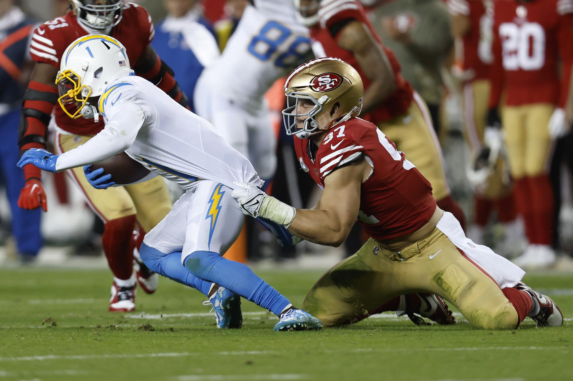 San Francisco 49ers defensive end Nick Bosa brings down Chargers wide receiver DeAndre Carter.