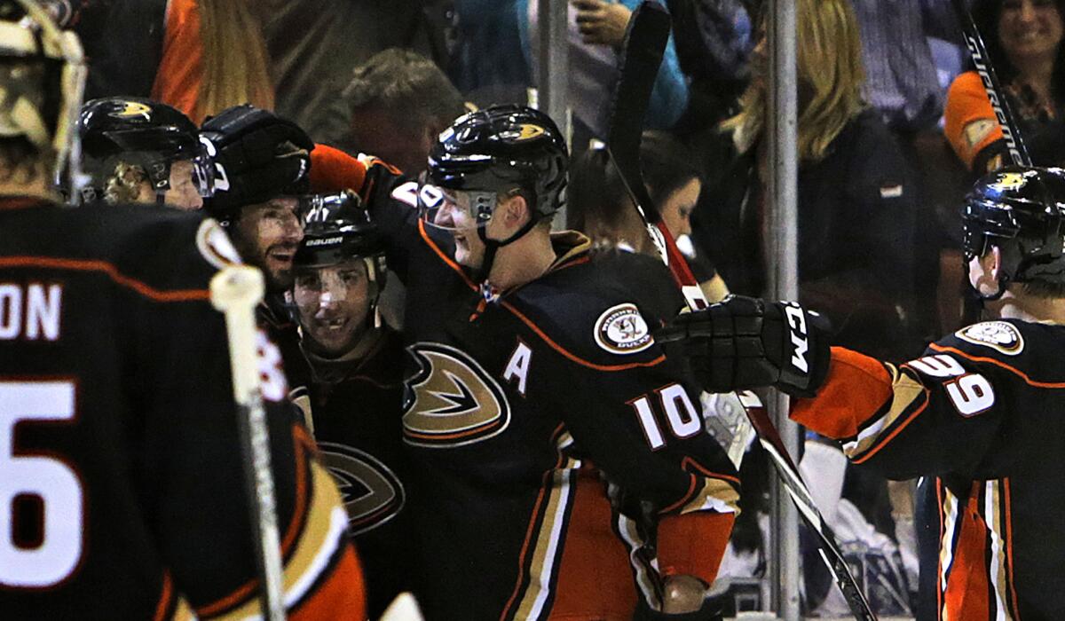 Ducks center Ryan Kesler gets a pat on the helmet from right wing Corey Perry (10) as they celebrate with left wing Matt Beleskey after their 3-2 overtime defeat of the Kings.