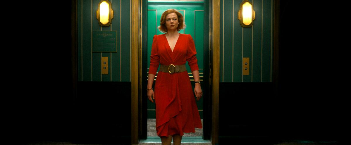A confident woman in a red dress walks off a green elevator