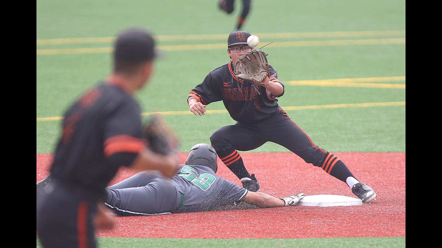 Huntington Beach High pitcher Edward Pelc tries to pick off South Hills runner J.C. Garate with a throw to shortstop Cole Minato during a Boras Classic South tournament opener at Mater Dei High on Tuesday.