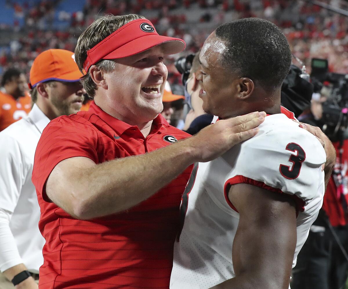 Georgia coach Kirby Smart and tailback Zamir White celebrate the team's win over Clemson in an NCAA college football game Saturday, Sept. 4, 2021, in Charlotte, N.C. (Curtis Compton/Atlanta Journal-Constitution via AP)