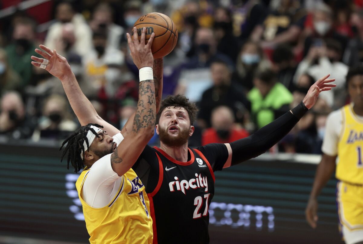 Lakers forward Anthony Davis and Portland Trail Blazers center Jusuf Nurkic battle for a rebound.