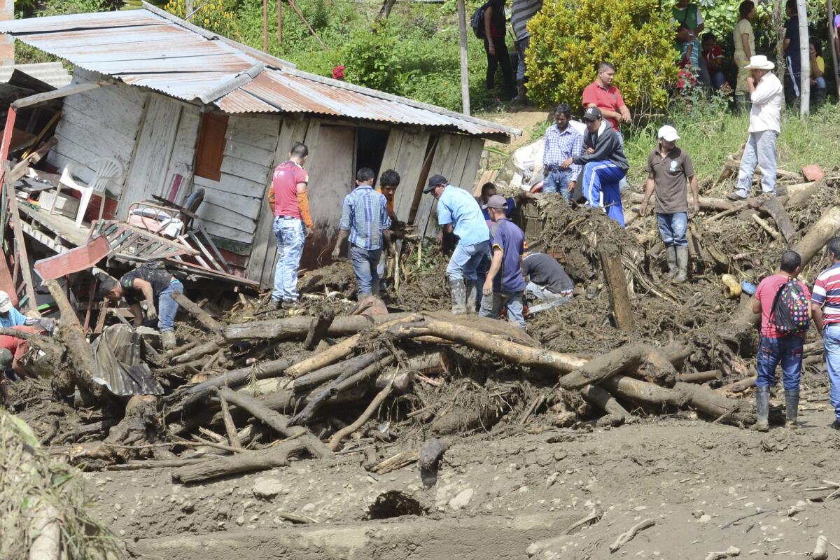 Residentes rescatan pertenencias de sus casas dañadas durante una avalancha, en Salgar, Colombia, el lunes 18 de mayo de 2015. Al menos 49 personas murieron cuando un desprendimiento de suelo ocasionado por lluvias torrenciales barrió las viviendas antes del amanecer. (Foto AP/Luis Benavides)