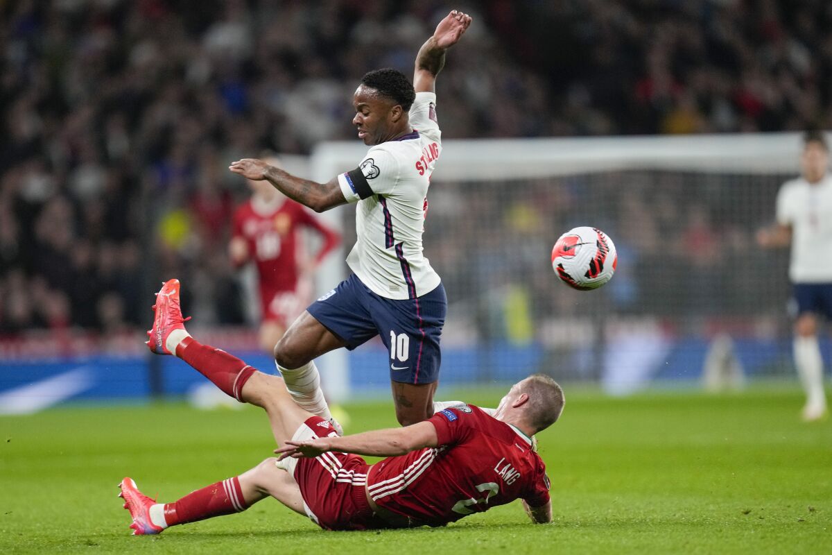 England's Raheem Sterling, top, is tackled by Hungary's Adam Lang during the World Cup 2022 group I qualifying soccer match between England and Hungary at Wembley stadium in London, Tuesday, Oct. 12, 2021. (AP Photo/Kirsty Wigglesworth)