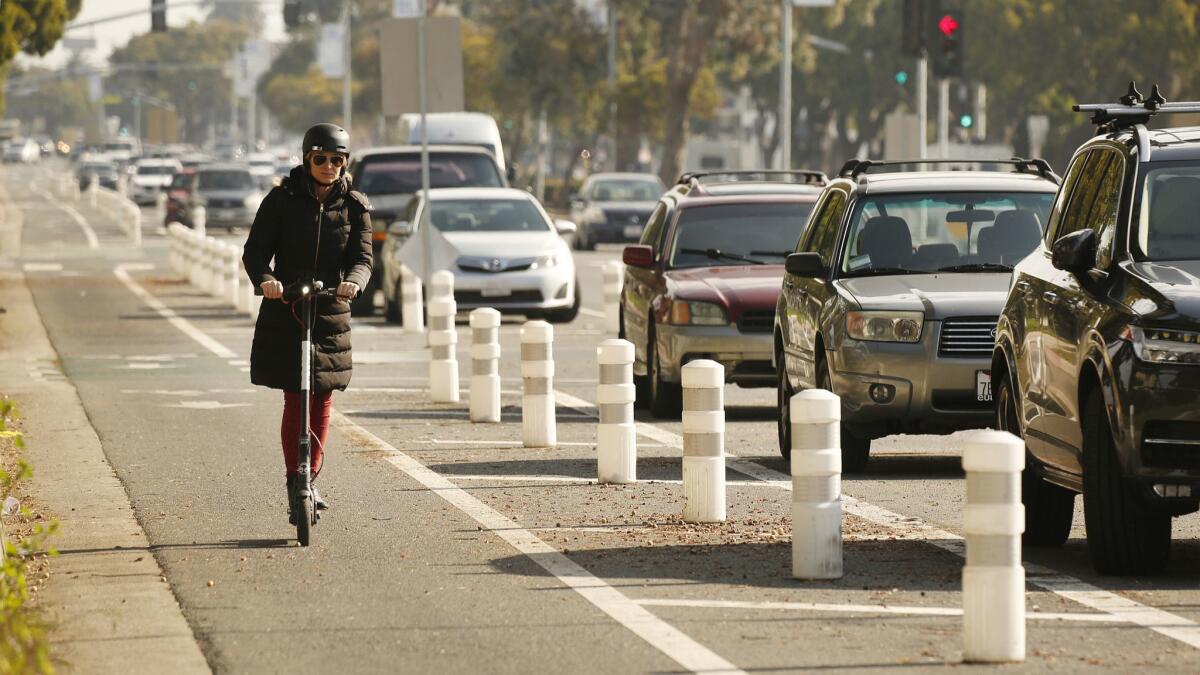 A scooter rider navigates the bike lane along Venice Boulevard in Mar Vista, Calif. on March 5.