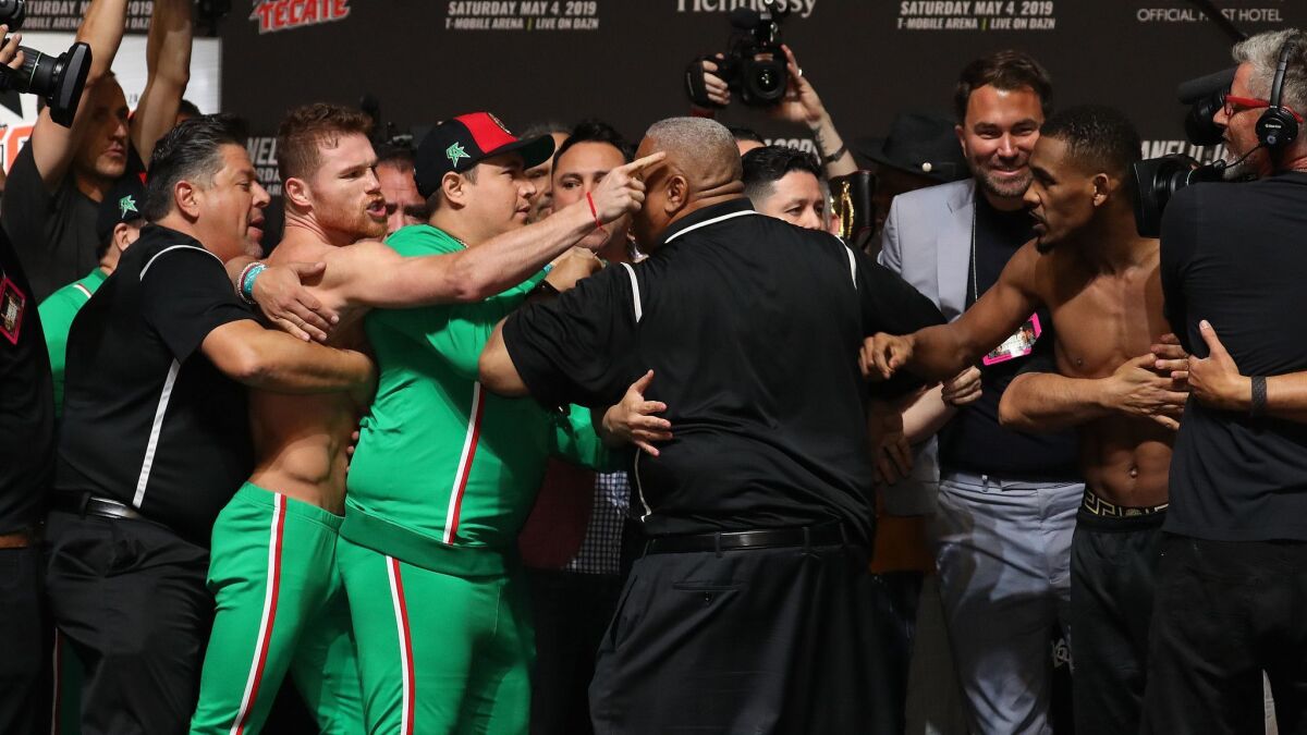 Canelo Alvarez and Daniel Jacobs get into a shoving match during their weigh-in at T-Mobile Arena on Friday in Las Vegas.