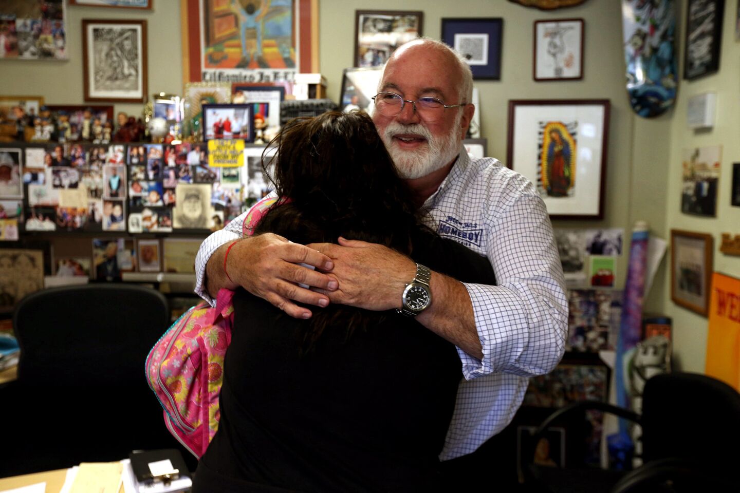Father Gregory Boyle gives a hug to Maria Lozoya, 20, after she came by his office for advice.