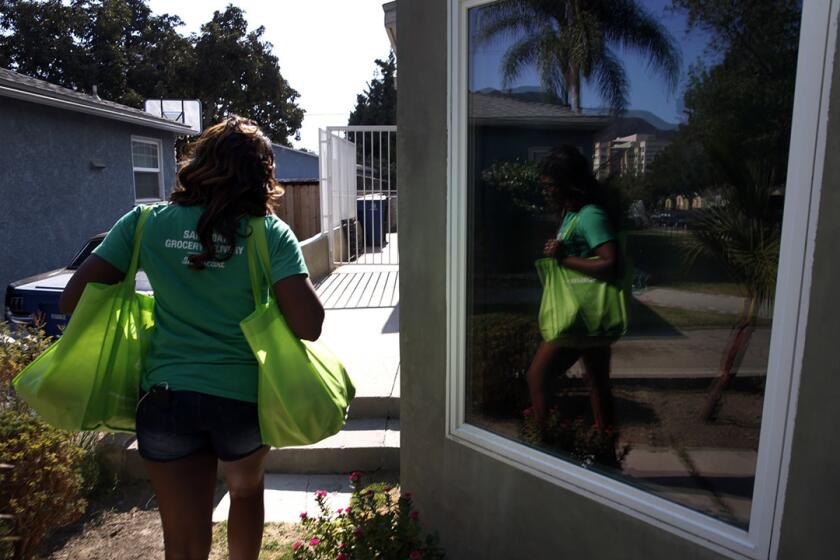 Instacart shopper Kara Pete delivers groceries to the home of Tricia Carr. Carr's job as director of mixology for Southern Wine & Spirits in Southern California requires frequent trips to the supermarket for ingredients for cocktails. With Instacart, she makes fewer of those trips.