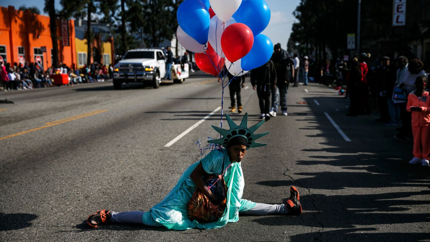 A woman dressed as Lady Liberty does the splits as she performs to promote Liberty Tax Service.