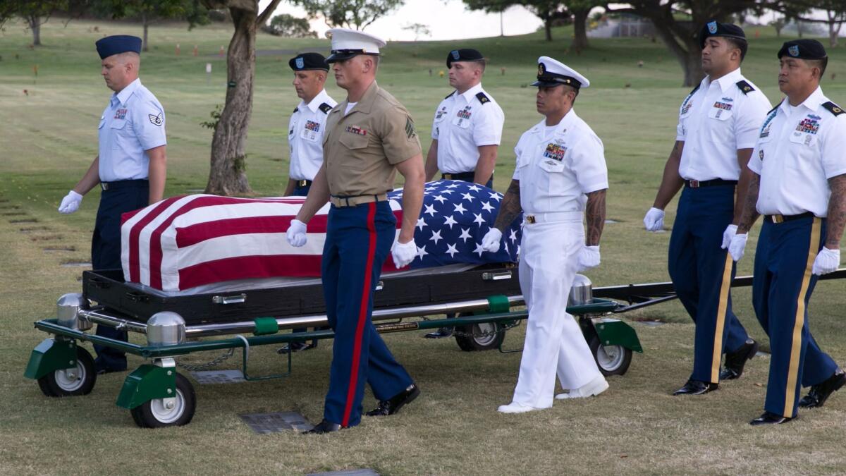 Pallbearers escort the remains of unidentified Oklahoma crew members that were exhumed in 2015 from the National Memorial Cemetery of the Pacific in Honolulu.