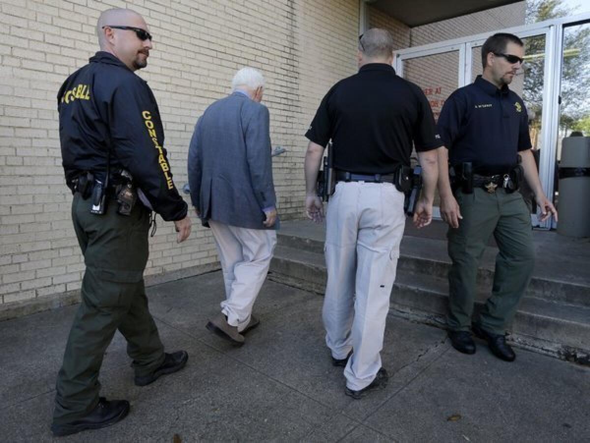 Kaufman County, Texas, law enforcement officials escort an employee inside the county courthouse. Security was increased after a second prosecutor was shot and killed.