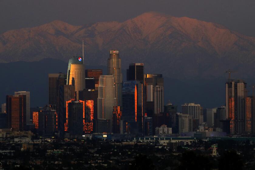 LOS ANGELES, CA - DECEMBER 27, 2019 - Snow covered San Gabriel Mountains provides a wintery backdrop for the downtown Los Angeles skyline as seen from Kenneth Hahn State Recreation Area in Los Angeles on December 27, 2019. Snow is the remnants of two storms that recently passed through the Southland. Another storm is expected to bring more rain to the region on Sunday. (Genaro Molina / Los Angeles Times)