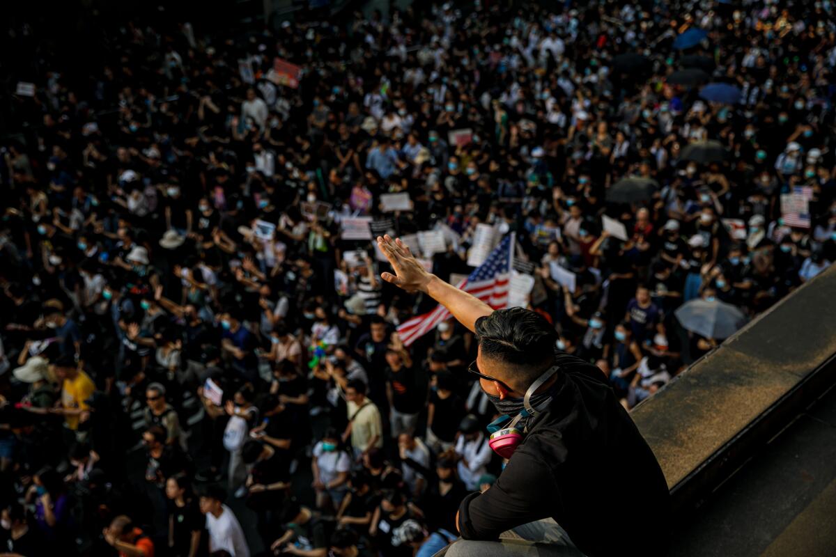 A demonstrator chants "five demands, not one less," as he cheers on other demonstrators at a pro-democracy rally near the United States Consulate in Hong Kong.