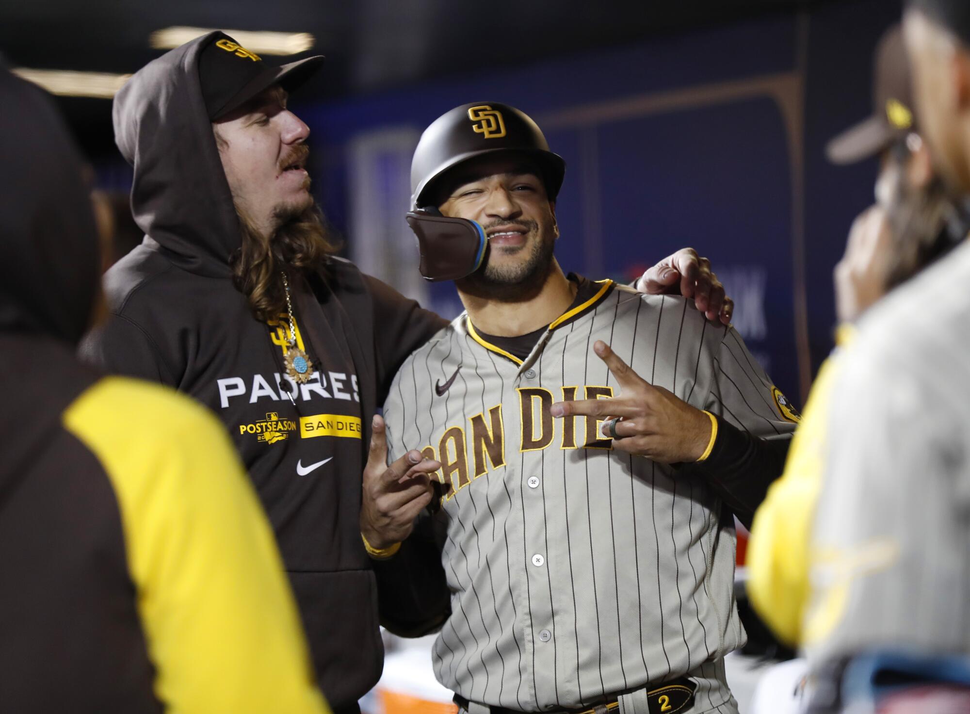 The Padres' Trent Grisham takes a photo with Mike Clevinger in the dugout after hitting a solo home run in the third inning.