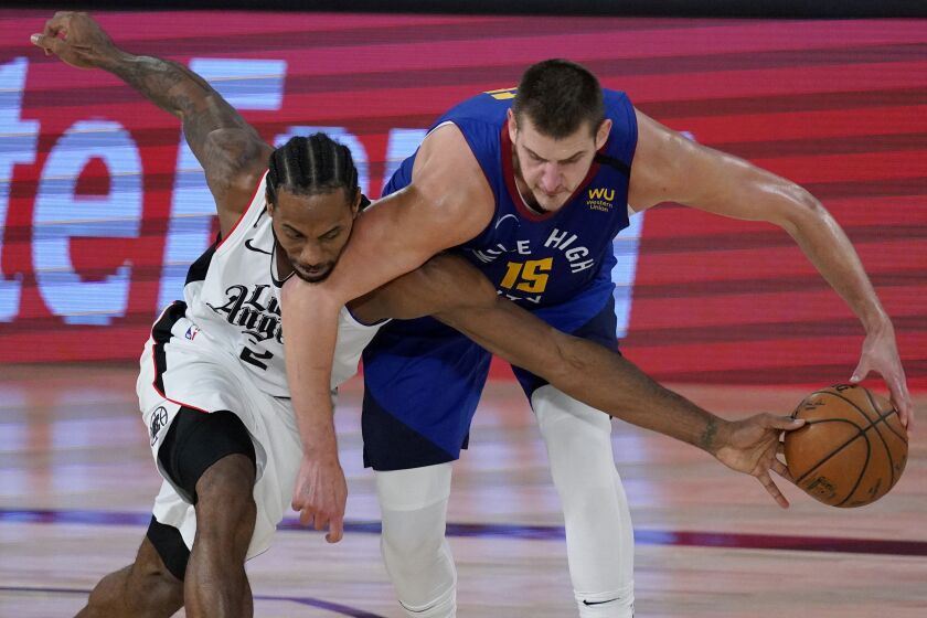 Clippers forward Kawhi Leonard tries to steal the ball from Nuggets center Nikola Jokic during Game 5 on Sept. 11, 2020.