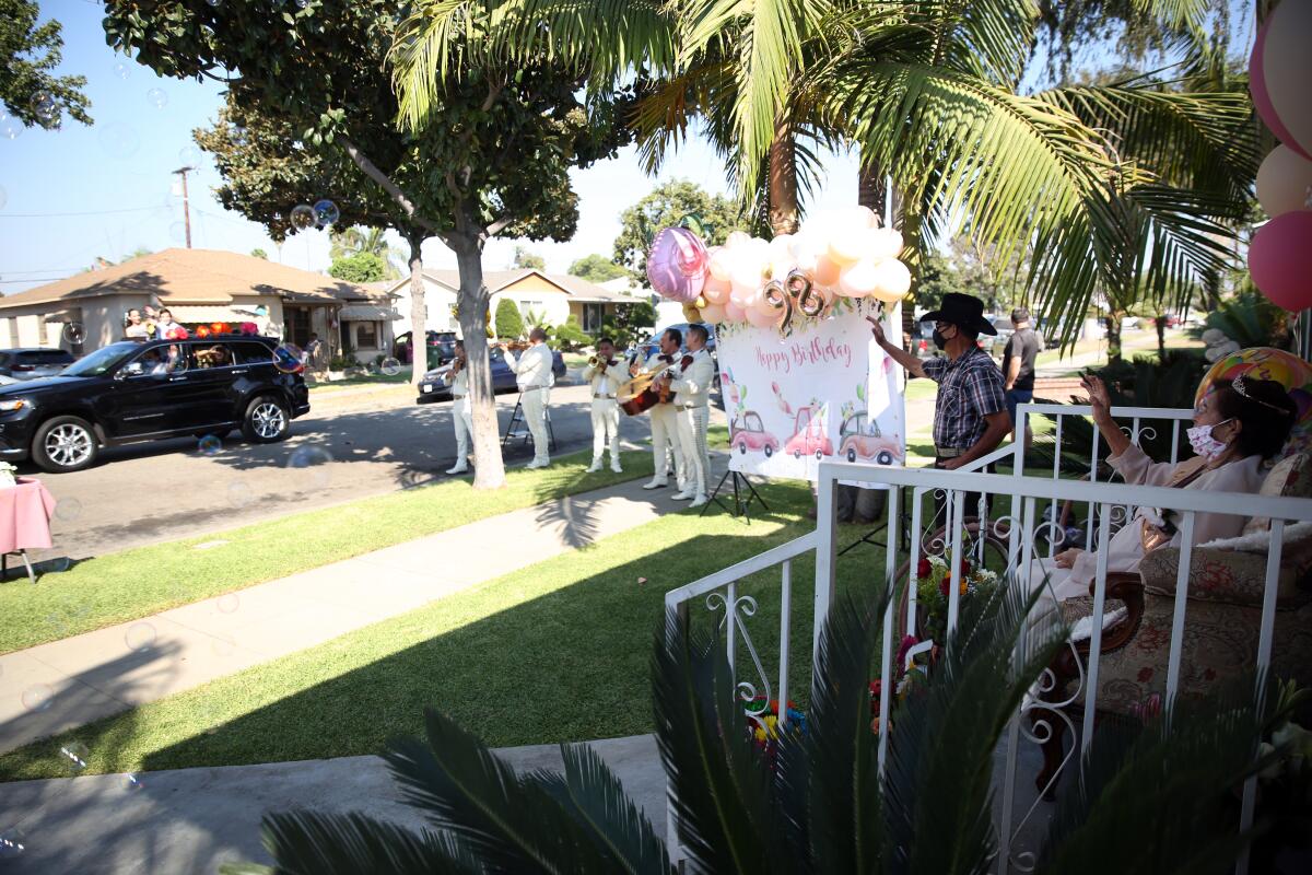 A caravan of cars pass in a celebration of Angelita Arellano's 98th birthday.