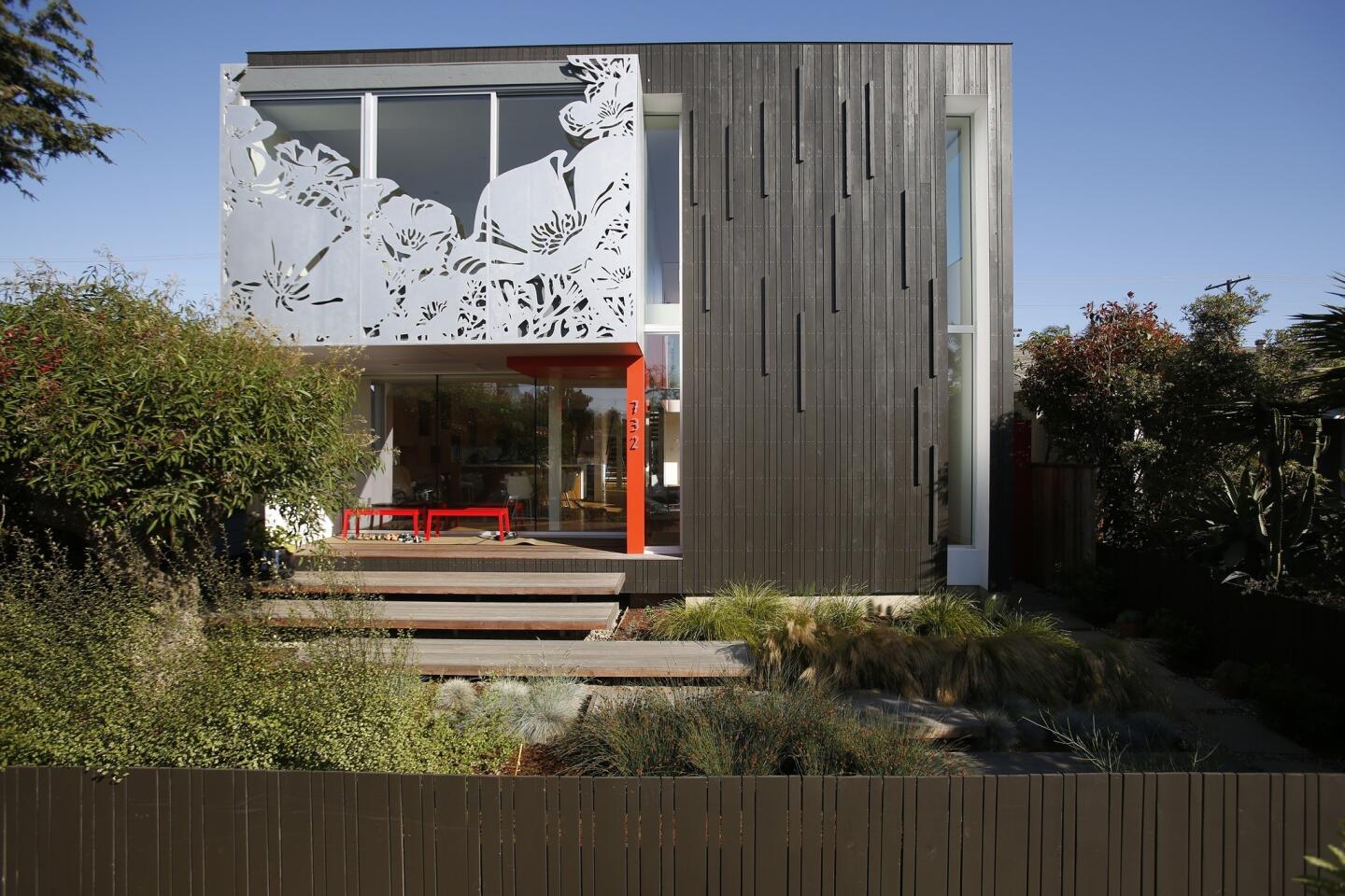 A floral silhouette cut into the second-floor aluminum screen creates a facade that wins second looks from passersby in Venice. Red accents on the ground floor of the house, designed by architect-owners Jonathan Ward and Jin Ah Park, reappear elsewhere, including on another aluminum panel visible from the interior courtyard.