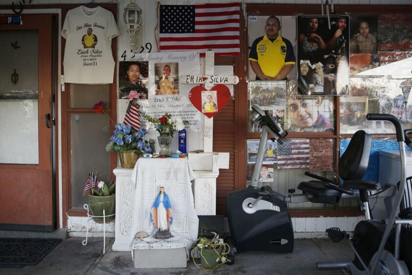 In this Sept. 19, 2018, photo, a makeshift memorial to Erick Silva is on display in front of his parent's home in Las Vegas. Silva was killed Oct. 1, 2017 in Las Vegas in the deadliest mass shooting in modern U.S. history. Silva was working as a security guard at the Route 91 Harvest Festival and was shot while helping people climb over a barricade to escape the gunfire. (AP Photo/John Locher)