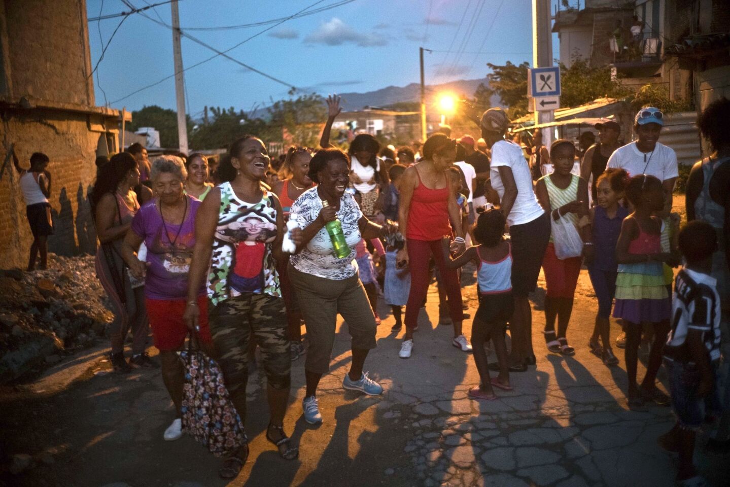 Vecinos bailan en la inauguración de una competición de lucha de nivel aficionado de una semana de duración organizada por vecinos del barrio de Chicharrones, en Santiago, Cuba.