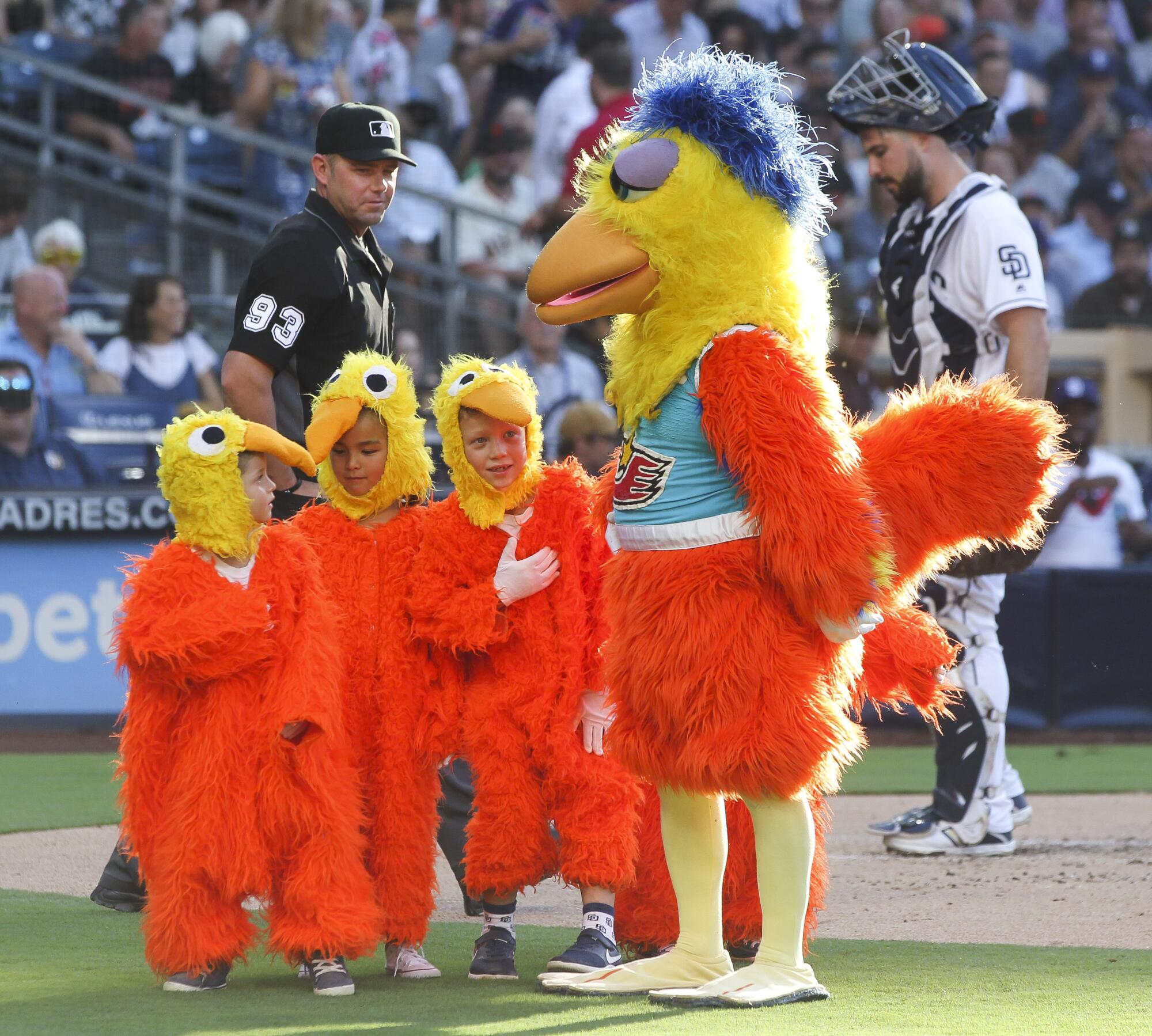 The Chicken leads a group of children dressed as baby chicks past catcher Austin Hedges during 2019 appearance at Petco Park.