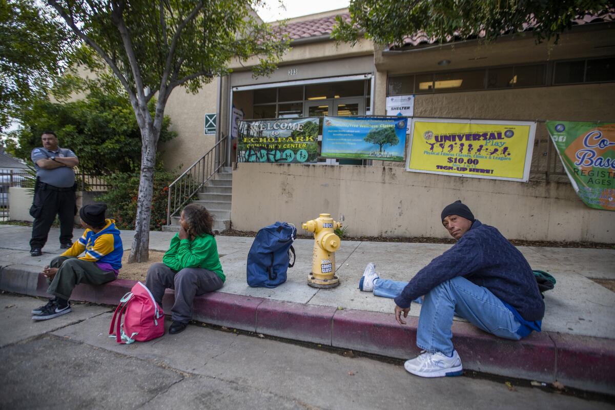 Tyrone Dixon, 53, right, arrives with other homeless people at the Echo Park Community Center, one of several recreation centers that are being converted to shelters.