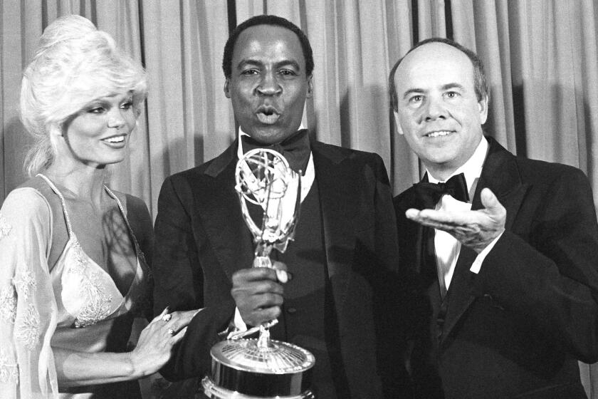 Guillaume, center, accepts his Emmy Award for supporting actor in a comedy-variety or music series for his role in "Soap" from Tim Conway, right, and Loni Anderson at the 31st Emmy Awards in Los Angeles on Sept. 10, 1979.