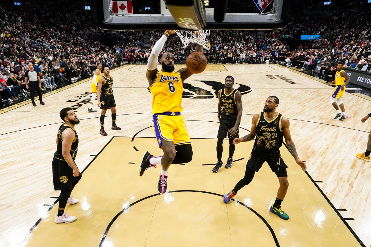Lakers forward LeBron James throws down a dunk against the Raptors.