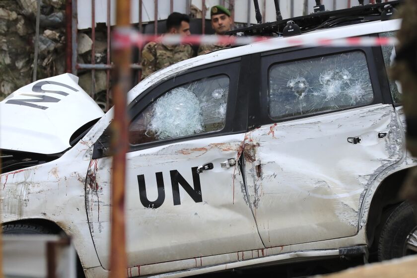 FILE - Lebanese soldiers stand behind a damaged vehicle after a UN peacekeepers convoy came under fire in the Al-Aqbiya village, south Lebanon, Thursday, Dec. 15, 2022. Lebanon's military tribunal Thursday charged five people affiliated with the militant group Hezbollah with criminal conspiracy and premeditated murder for the killing of an Irish UN peacekeeper in December, a senior judicial official said. (AP Photo/Mohammed Zaatari, File)