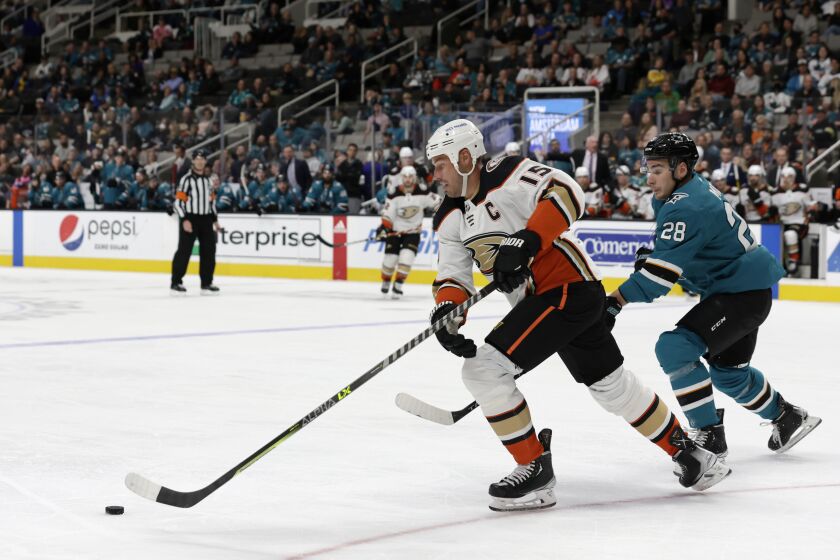 Ducks center Ryan Getzlaf (15) handles the puck as Sharks right wing Timo Meier (28) defends March 26, 2022.