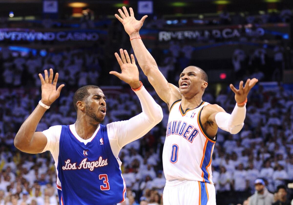 Clippers point guard Chris Paul, left, draws a foul call on a three-point attempt by Oklahoma City point guard Russell Westbrook during the closing seconds of the Clippers' 105-104 road loss in Game 5 of the Western Conference semifinals Tuesday.
