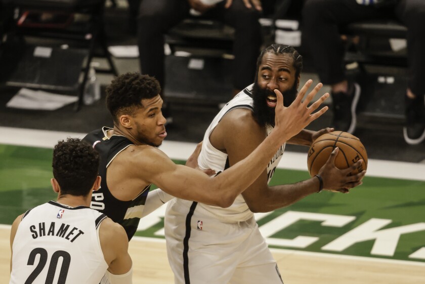 Brooklyn Nets' James Harden, right, is guarded by Milwaukee Bucks forward Giannis Antetokounmpo, center, during the first half of Game 6 of a second-round NBA basketball playoff series Thursday, June 17, 2021, in Milwaukee. (AP Photo/Jeffrey Phelps)