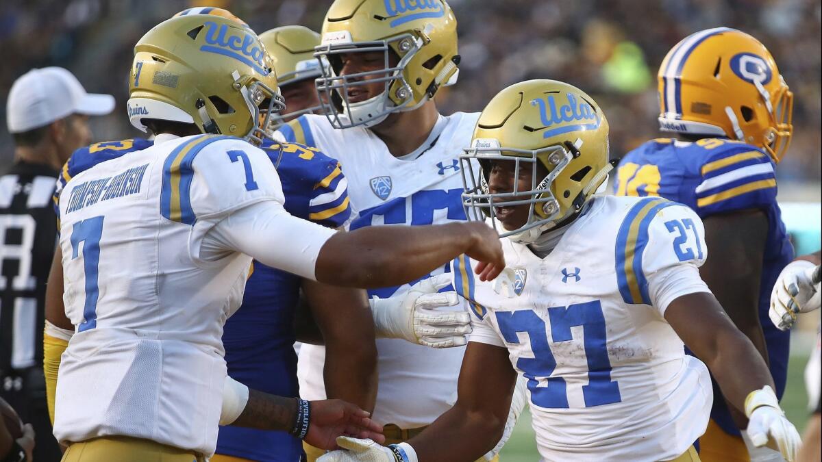 UCLA's Joshua Kelley (27) celebrates with quarterback Dorian Thompson-Robinson (7) after scoring a touchdown against California in the second half on Saturday in Berkeley.