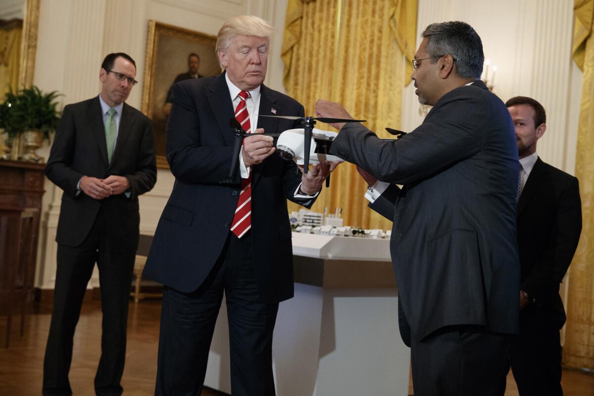 President Trump looks at a drone at a technology event in the East Room of the White House.