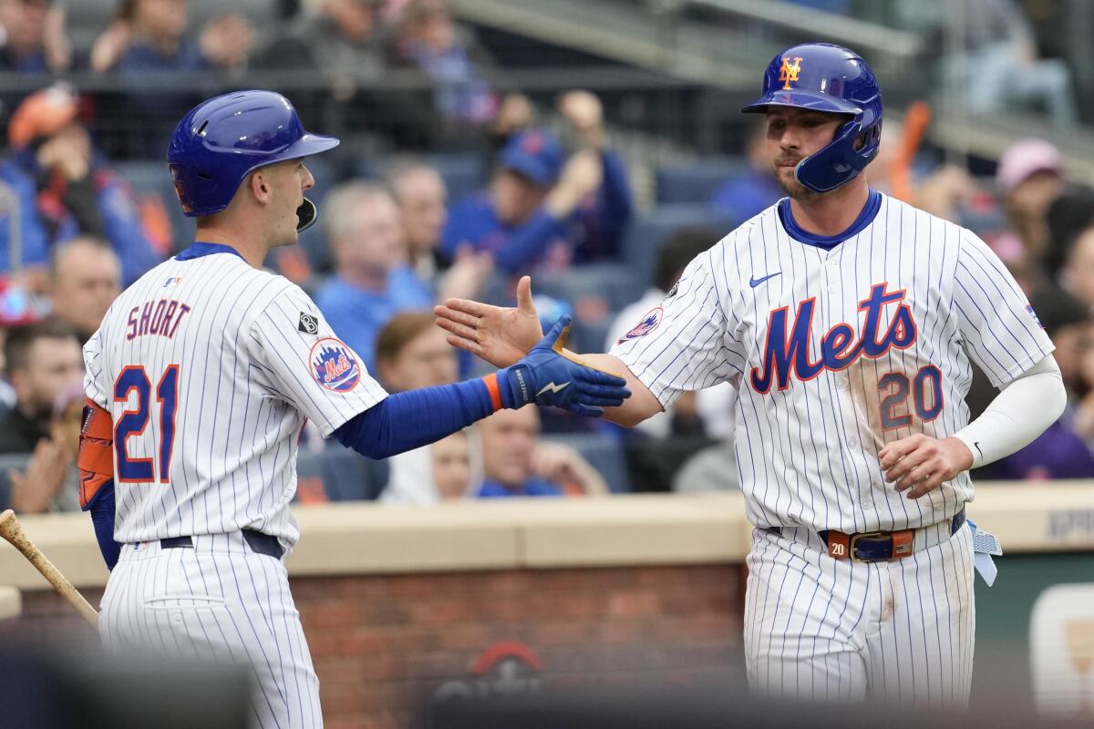 New York Mets' Pete Alonso (20) celebrates with New York Mets' Zack Short (21) after scoring on a two-run single by Tyrone Taylor during the sixth inning of a baseball game against the Pittsburgh Pirates, Wednesday, April 17, 2024, in New York. (AP Photo/Mary Altaffer)