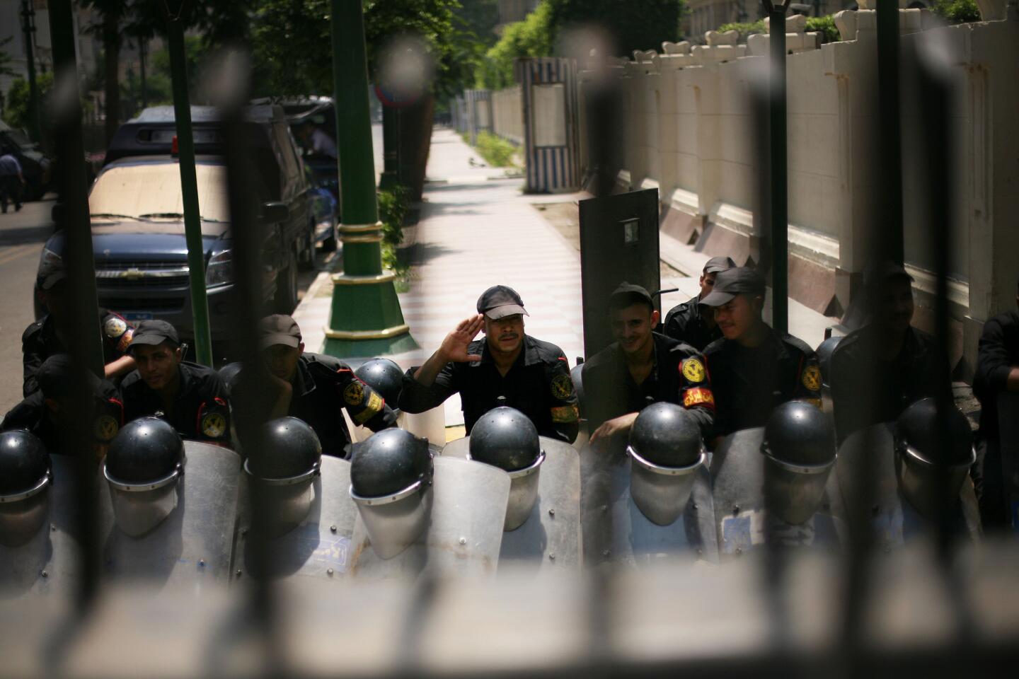 Anti-riot soldiers sit behind a gate barring entry to the Egyptian parliament in Cairo.