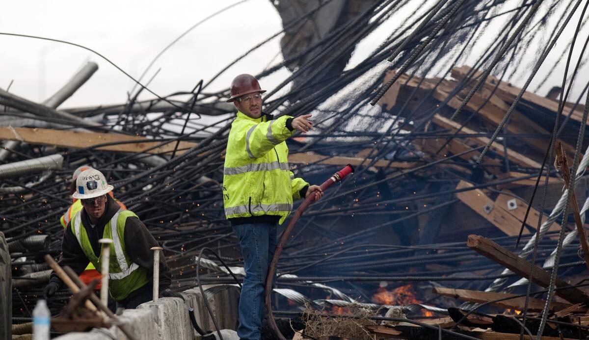 A worker from Security Paving gives directions at the collapsed Ranchero Road overpass on I-15 in Hesperia.