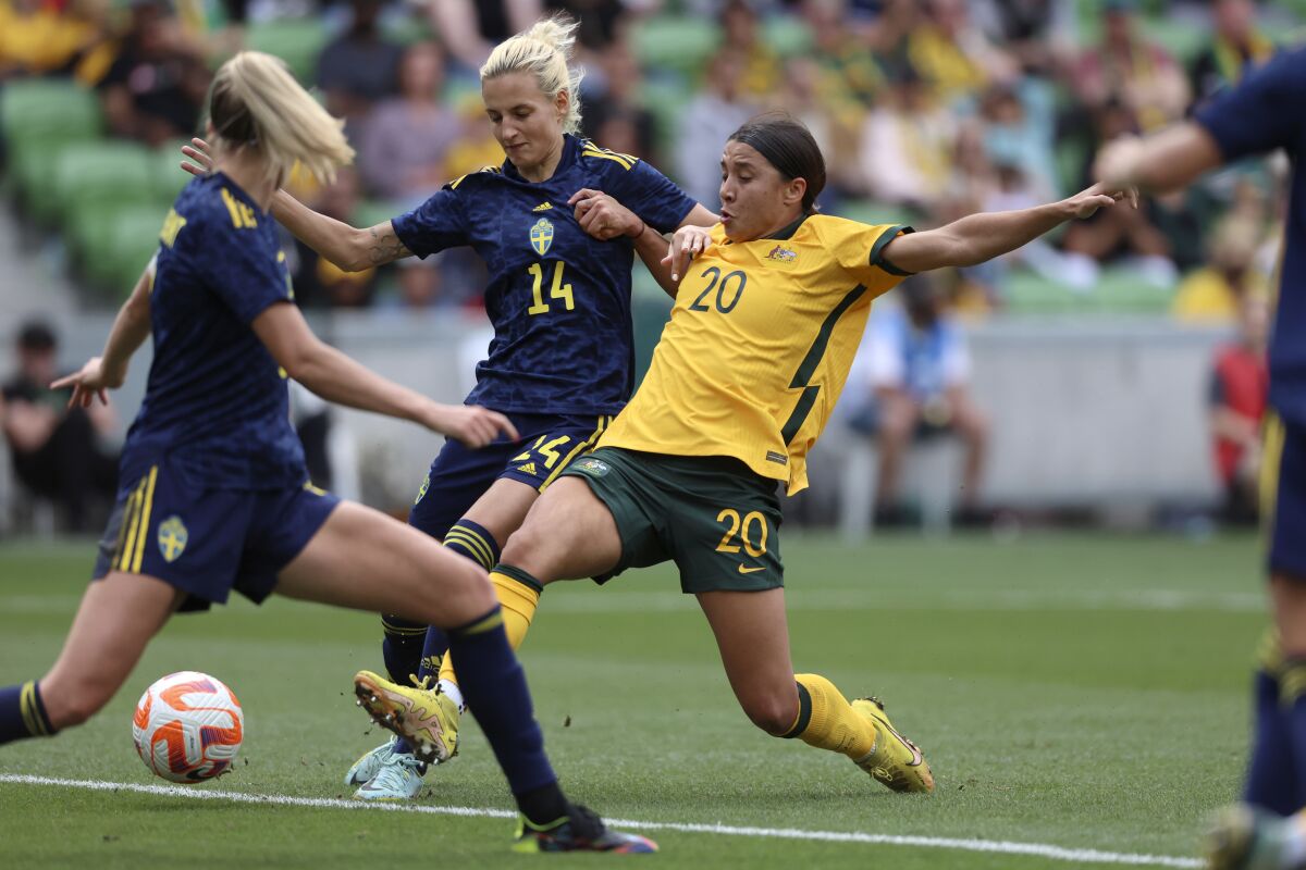 FILE - Australia's Sam Kerr (20) scores against Sweden's Nathalie Bjorn (14) during their women's friendly soccer match in Melbourne, Australia, Nov. 12, 2022. Australia's opening Women's World Cup match against Ireland has been moved to Stadium Australia in Sydney because of ticket demand, FIFA announced. The tournament, co-hosted by Australia and New Zealand, starts on July 20, 2023. (Asanka Brendon Ratnayake, File)