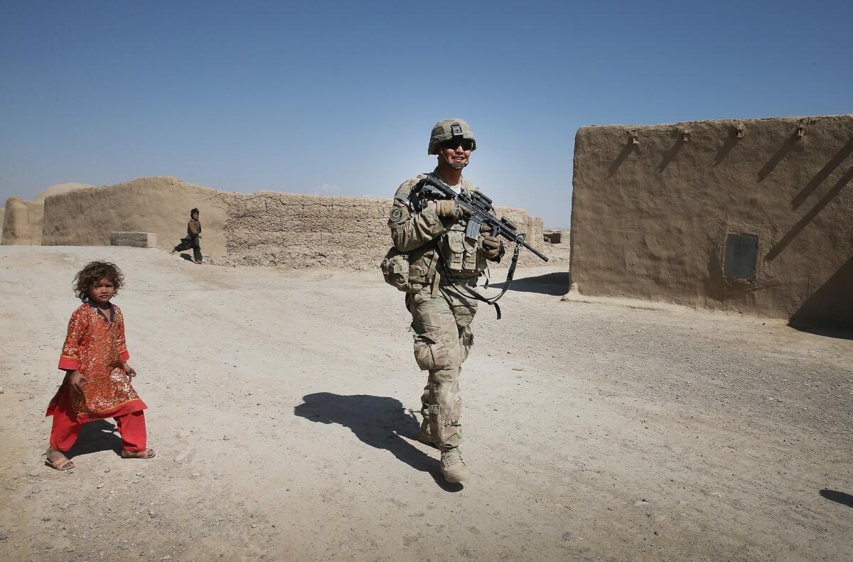 PFC Joshua Best of Ft. Benning, Ga., with the U.S. Army's 4th squadron 2d Cavalry Regiment, patrols Thursday through a village near Kandahar, Afghanistan.