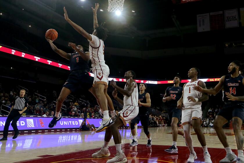 LOS ANGELES, CALIF. - DEC. 7, 2022. Fullerton guard Daeshawn Eatontian goes to the basket against USC guard Boogie Ellis in the second half at Galen Center in Los Angeles on Wednesday night, Dec. 7, 2022. (Luis Sinco / Los Angeles Times)