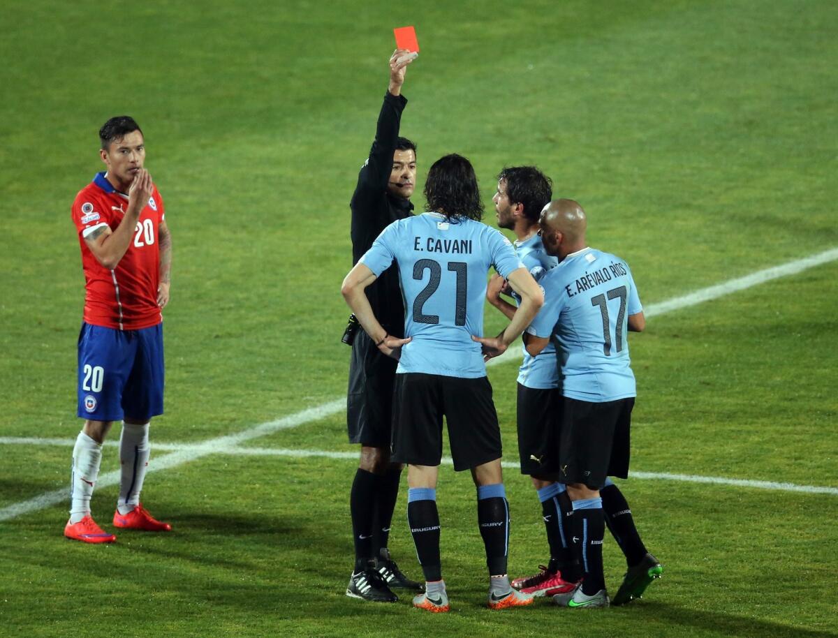 Brazilian referee Sandro Ricci (2nd L) shows the red card to Uruguay's forward Edinson Cavani during their 2015 Copa America football championship quarterfinal match, in Santiago, on June 24, 2015. AFP PHOTO / CLAUDIO REYESClaudio Reyes,Claudio Reyes/AFP/Getty Images ** OUTS - ELSENT, FPG - OUTS * NM, PH, VA if sourced by CT, LA or MoD **