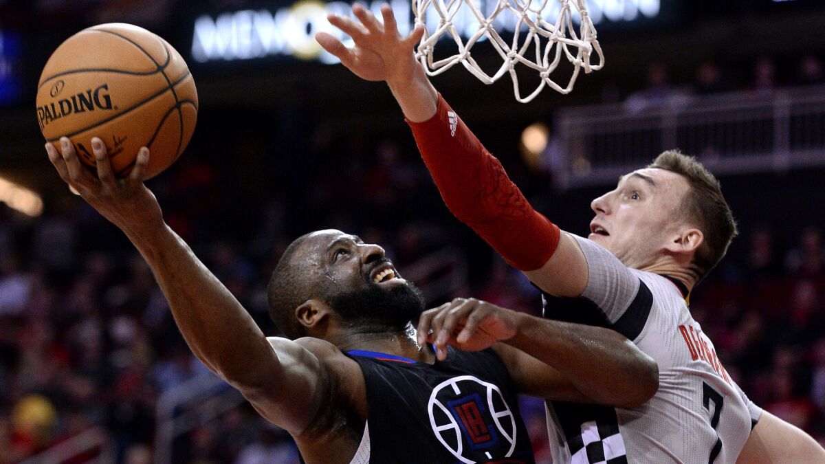 Clippers guard Raymond Felton has his layup challenged by Rockets forward Sam Dekker during the first half Friday night in Houston.