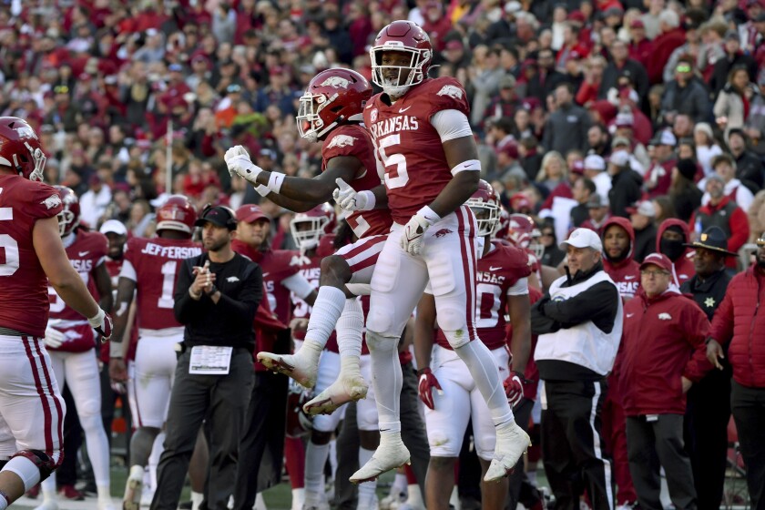 Arkansas running back Raheim Sanders (5) celebrates with teammate Trelon Smith (22) after scoring a touchdown against Missouri during the first half of an NCAA college football game Friday, Nov. 26, 2021, in Fayetteville, Ark. (AP Photo/Michael Woods)